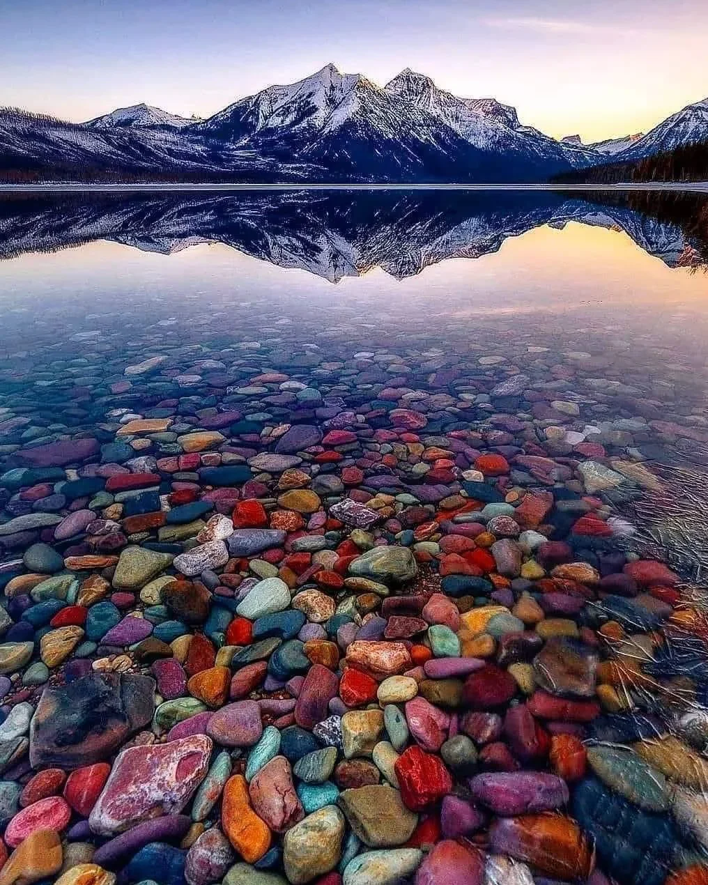 Close-up of colorful argillite pebbles at Lake McDonald — vivid reds, greens and purples created by 1.5 billion years of iron oxidation