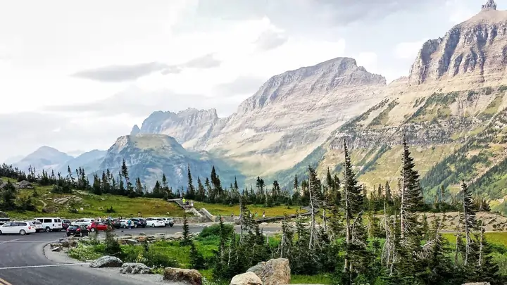 Panoramic view of Logan Pass alpine meadows under dramatic skies in Glacier National Park