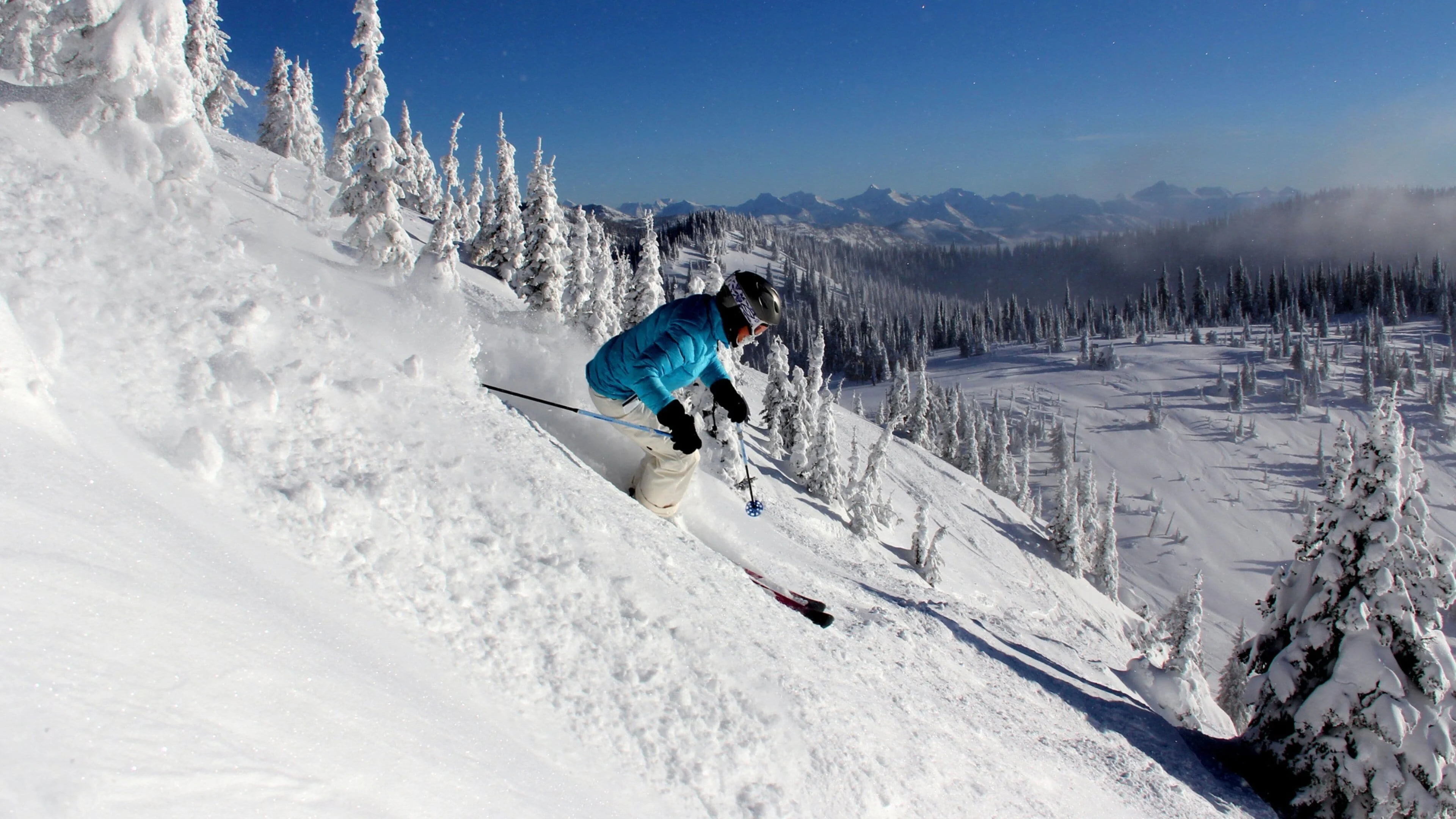 Skiing at Whitefish Mountain Resort with Glacier National Park peaks visible in the background