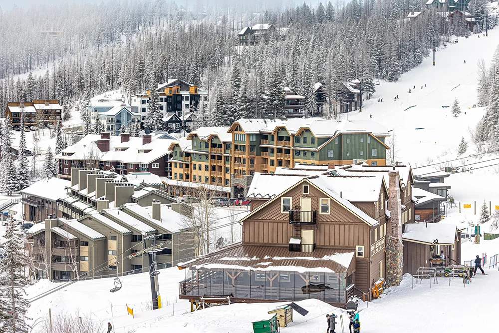 Skiers on the slopes of Whitefish Mountain Resort with panoramic winter mountain views